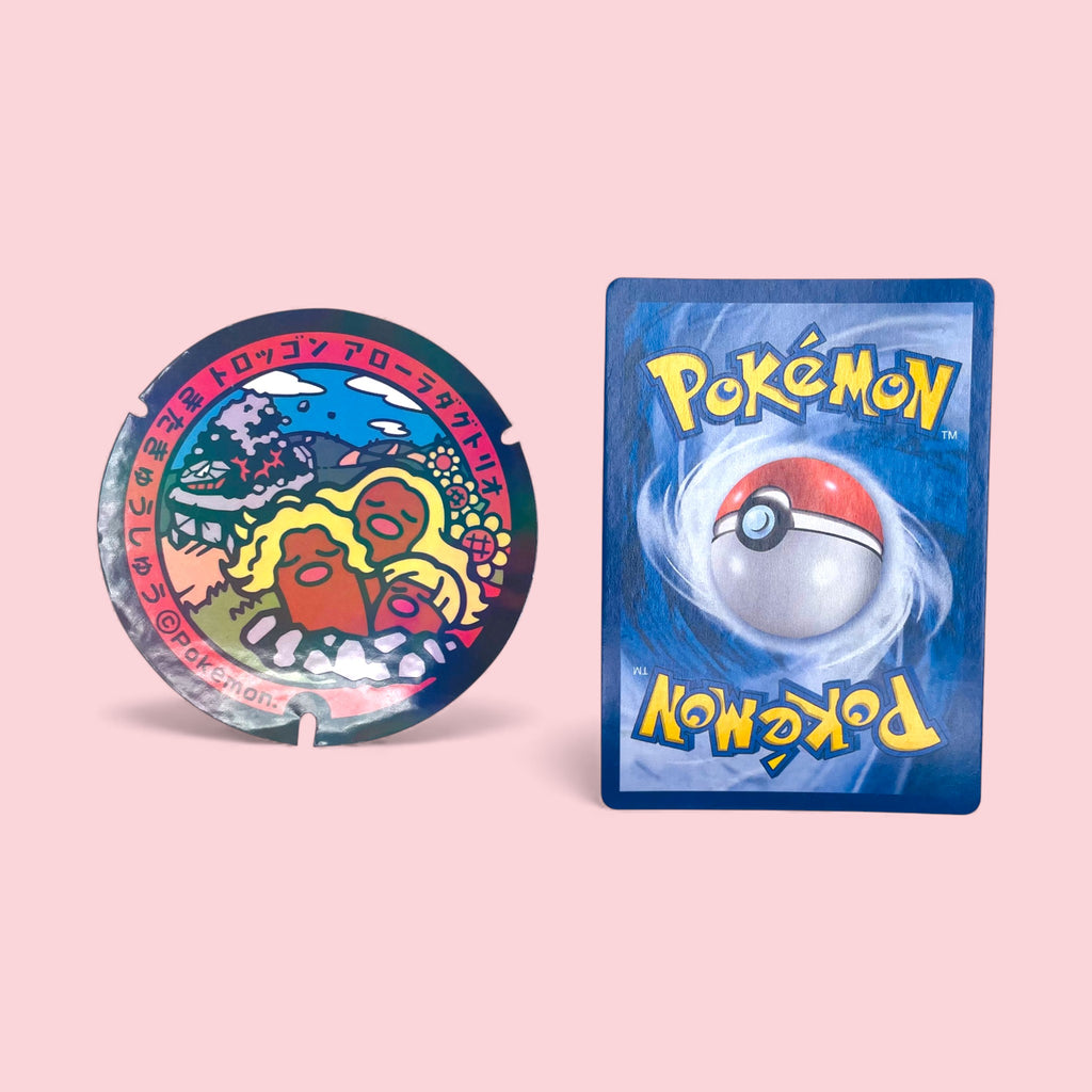 Alolan Dugtrio Poke-Lid Collectible Sticker Gamer Decor next to Pokemon card